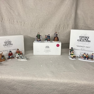 May include: Three sets of miniature porcelain figurines depicting scenes from a farm, a market, and a village. The sets are packaged in boxes with the text "Heritage Village Collection" and the names of the scenes. The figurines are hand-painted and detailed.