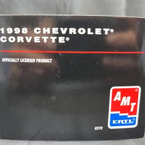 Puede incluir: Caja negra con el texto "1998 Chevrolet Corvette" y "Officially Licensed Product". Una l&iacute;nea roja separa el texto. La caja tiene un logotipo de AMT ERTL y el n&uacute;mero 8270.