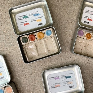 colori ad acquerello vegani fatti a mano in ciotole di ceramica con una tavolozza di miscelazione