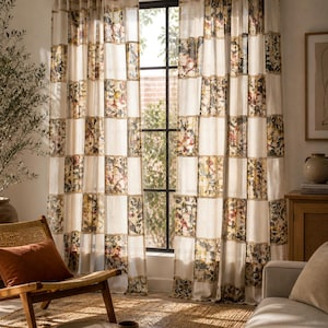 May include: A pair of floor-length curtains featuring a checkered pattern of alternating solid off-white panels and panels with a multi-coloured floral print. The curtains are hung on a black rod and cover a window with a black grid frame.