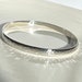 Hammered sterling silver bangle bracelet. Solid silver bangle. 925 hallmarked silver to enhance pretty wrists. Catches the light 