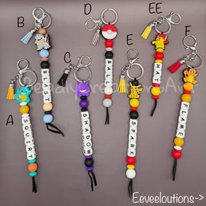 May include: Seven keychains featuring colorful silicone beads, letter beads spelling words like SQUIRT, BLAST, SHADOW, BALL, HAT, SPARK, and FLAME, and character charms including Squirtle, Blastoise, Gengar, Pikachu, and Charmander with metal rings.
