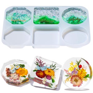 May include: A clear silicone mold with various shaped cavities, including hexagons, squares, and circles. The mold contains three finished resin coasters with dried flowers and three resin coasters with glitter and the words "happiness", "blessing", and "lucky".
