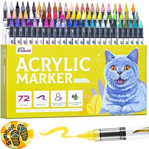 May include: A set of 72 acrylic markers in various colors, displayed in a yellow box with a blue cat illustration. The box reads "Acrylic Marker" and includes icons for brush tip, artist-chosen colors, and vibrant colors. A yellow marker is shown with a stroke of yellow ink.