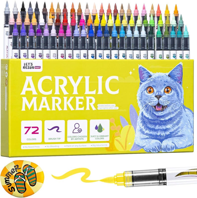 May include: A set of 72 acrylic markers in various colors, displayed in a yellow box with a blue cat illustration. The box reads "Acrylic Marker" and includes icons for brush tip, artist-chosen colors, and vibrant colors. A yellow marker is shown with a stroke of yellow ink.