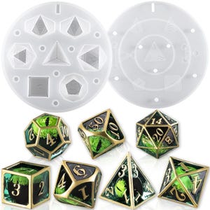 May include: A set of seven polyhedral dice with a green and gold finish. The dice are in the shape of a d4, d6, d8, d10, d%, d12, and d20. The dice are sitting on a white surface. The dice are also shown in a clear silicone mold.