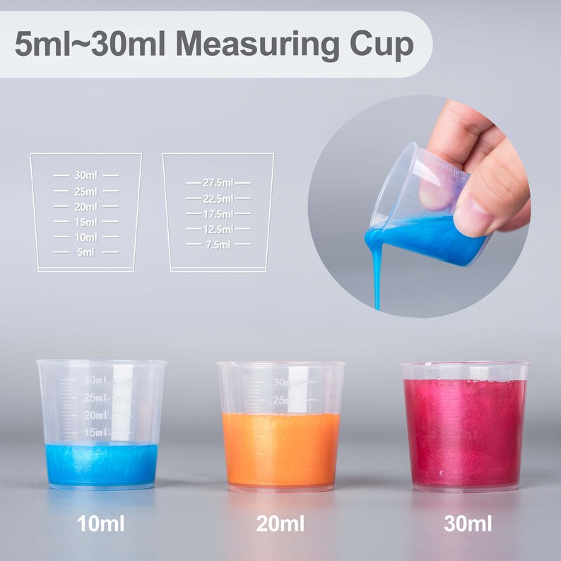 May include: Three clear plastic measuring cups with blue, orange, and red liquid inside. The cups are labeled 10ml, 20ml, and 30ml. A separate image shows a clear plastic measuring cup with blue liquid being poured from it.