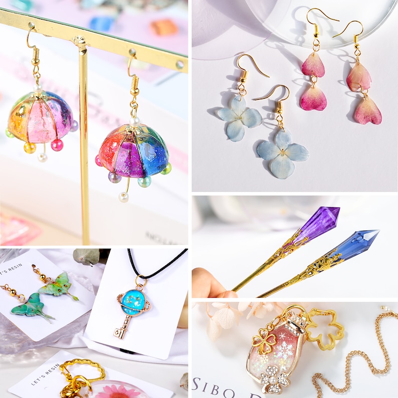 May include: Assortment of handmade resin jewelry featuring various designs, including a colorful umbrella, pressed flowers, a key with a planet charm, a bottle with glitter and snowflakes, and a crystal-shaped hair stick.