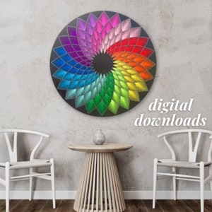 Op de afbeelding: Een kleurrijk regenboogmandala gemaakt met string art op een zwarte ronde houten basis. De mandala is gemaakt met verschillende kleuren garen, waaronder rood, oranje, geel, groen, blauw, indigo en violet. De mandala wordt omringd door een witte muur en twee witte stoelen.