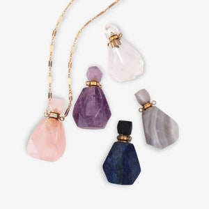 May include: A gold chain necklace with five crystal perfume bottles. The bottles are made of clear quartz, amethyst, rose quartz, lapis lazuli, and agate.