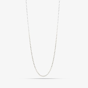 May include: A long, slender silver chain necklace featuring a series of small, uniform oval-shaped links connected in a continuous loop. The metallic surface has a polished finish that reflects light, creating a bright and clean appearance.