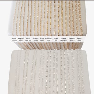 May include: A display of gold-filled and sterling silver chains in various styles, including dainty, link, flat bar, cable, oval, bar, paperclip, hearts, and circle. The chains are arranged in two rows on a white surface. The text "Shop our Gold Filled and Sterling Silver Chains Premium Quality, Made in the USA" is at the top of the image.