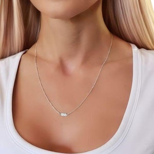 May include: A silver chain necklace with a small silver charm that says "555". Shown top to bottom: Kaylani dainty chain, Whitney angel 555.