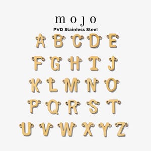 May include: Gold-colored alphabet letter charms, A through Z, with small loops for attaching to jewelry. The word "mojo" is above the letters, with "PVD Stainless Steel" below it. The letters are displayed on a white background.