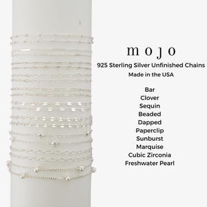 May include: A collection of delicate 925 sterling silver unfinished chains, including bar, clover, sequin, and beaded designs. The image displays various chain styles, with the brand name "mojo" and text "Made in the USA".