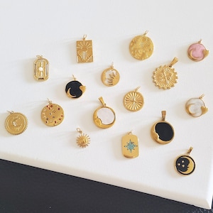 Puede incluir: Una colección de 18 colgantes de tono dorado con diseños celestiales y de estrellas. Los colgantes incluyen una variedad de formas, incluyendo círculos, cuadrados y medias lunas. Algunos colgantes presentan detalles intrincados, como estrellas, lunas y soles.