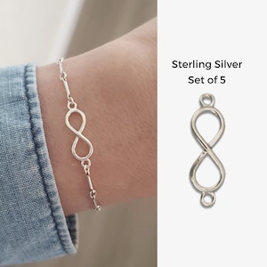 Peut inclure: Un ensemble de cinq pendentifs de charme infini en argent sterling. Les breloques sont en forme de symbole d'infini et ont une petite boucle en haut pour être attachées à un bracelet ou un collier.