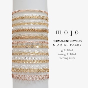 May include: A selection of gold filled, rose gold filled, and sterling silver chains are displayed against a white backdrop. The chains are arranged vertically, with the top chain being gold filled and the bottom chain being sterling silver. The text "mojo PERMANENT JEWELRY STARTER PACKS" is displayed below the chains. The text "gold filled, rose gold filled, sterling silver" is displayed below the text "STARTER PACKS".