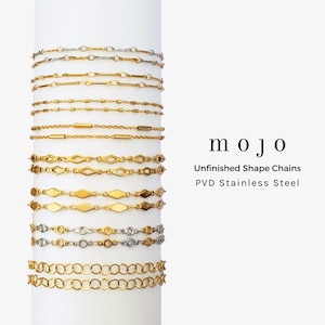 May include: A collection of gold and silver-toned chain necklaces with various link designs. The chains are displayed on a white cylindrical stand. The image includes the text "mojo", "Unfinished Shape Chains", and "PVD Stainless Steel".