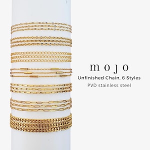 May include: Gold-colored unfinished chain necklaces in six different styles are displayed on a white cylindrical stand. The text "mojo" is visible, along with the description "Unfinished Chain, 6 Styles, PVD stainless steel."