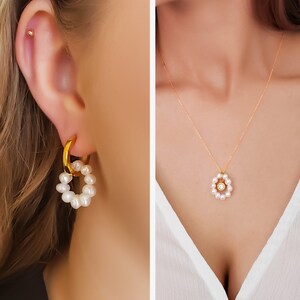 May include: Gold hoop earrings with a cluster of white pearls. A gold necklace with a pearl pendant is also shown. The pendant has a central gem surrounded by pearls. The text in the image reads: Waylon hoop, Ambre pearl, Sloane necklace, Ambre pearl.