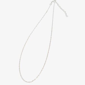 May include: A silver-toned metal chain necklace featuring delicate, interlocking oval links. The necklace includes a small circular clasp at one end and a short length of adjustable extender chain with larger links at the other end.