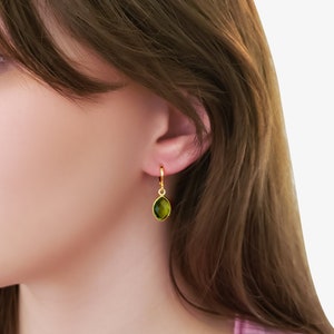 May include: Gold hoop earrings with a green gemstone pendant. Shown from top to bottom: Jolie hoop, Cairo crystal.