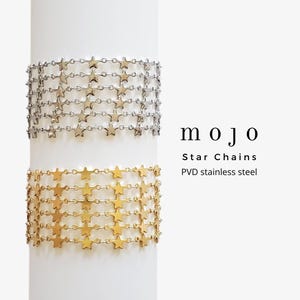 May include: Two gold and silver star chain bracelets. The bracelets are made of PVD stainless steel. The text "mojo Star Chains PVD stainless steel" is visible below the bracelets.