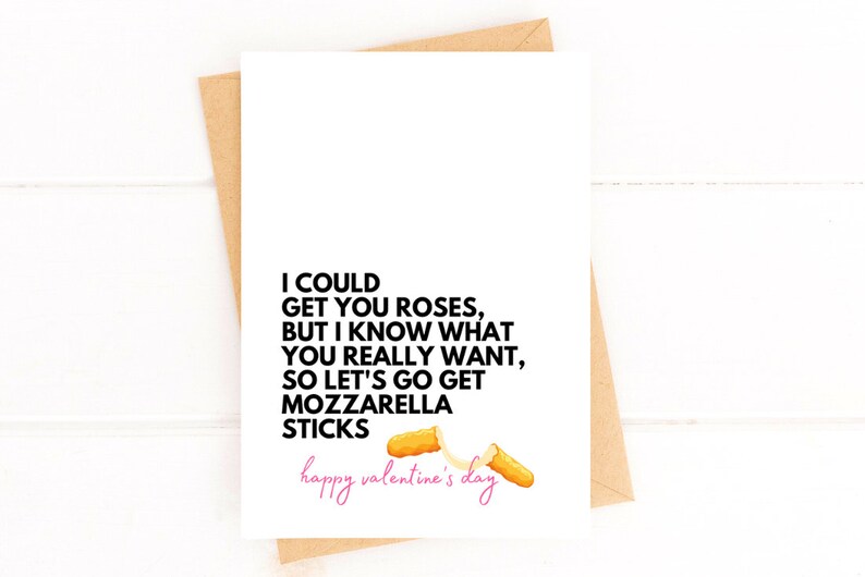 May include: A white Valentine's Day card with the text "I COULD GET YOU ROSES, BUT I KNOW WHAT YOU REALLY WANT, SO LET'S GO GET MOZZARELLA STICKS" in black. The words "happy valentine's day" are in pink. Two mozzarella sticks are illustrated.