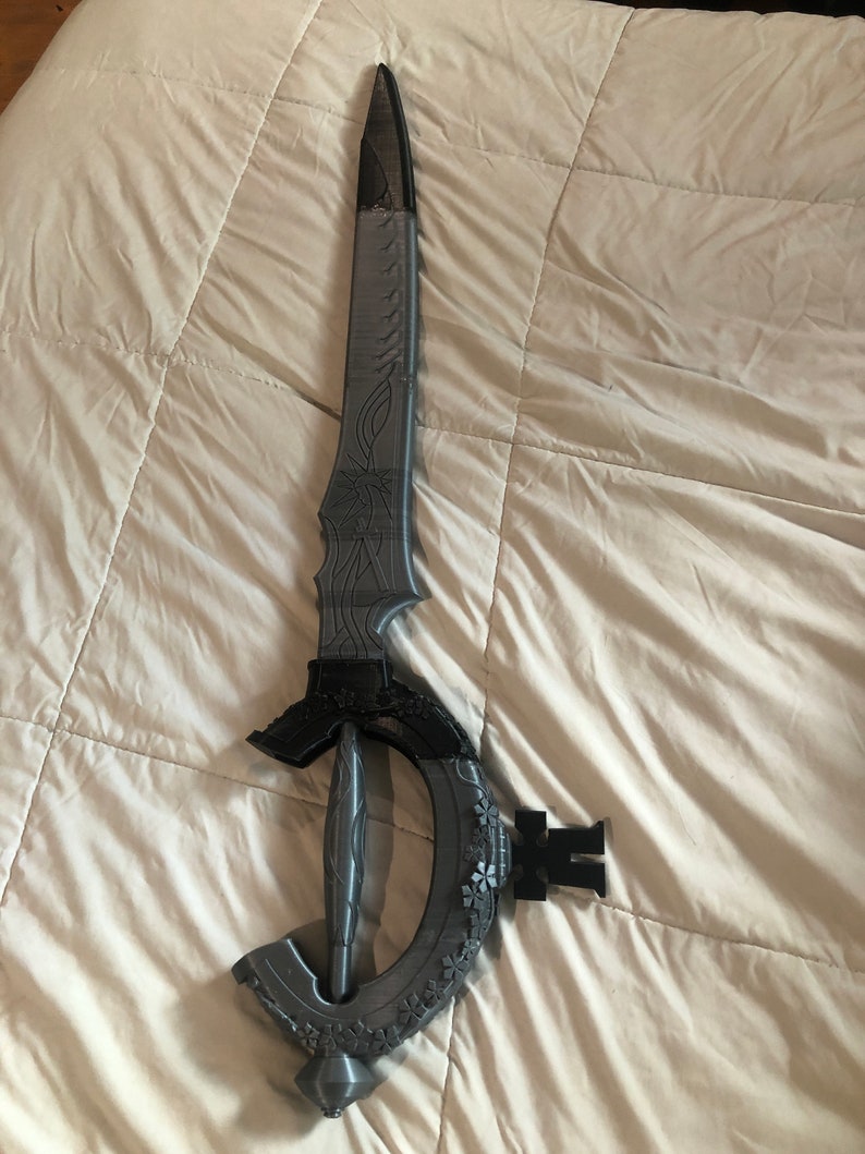 May include: A gray 3D printed sword with intricate details and a curved handle.
