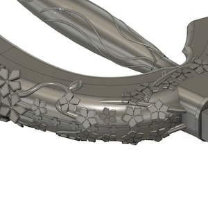 May include: A silver-colored metal sword with a decorative floral design. The sword has a curved blade and a handle with a cross-shaped guard.