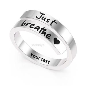 May include: Silver ring with the words "Just breathe" and a small heart engraved on it. The ring has a space for personalized text.