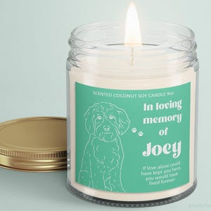 May include: A white soy candle with a green label that says "In loving memory of Joey". The label also features a line drawing of a dog and the text "If love alone could have kept you here, you would have lived forever".