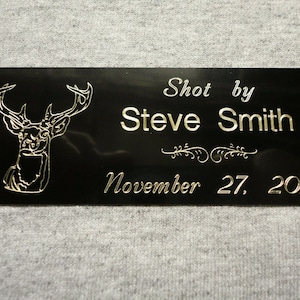 May include: Black plaque with a gold deer silhouette and the text "Shot by Steve Smith November 27, 2018".