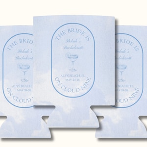 Pode incluir: Três coolers de lata azul claro com um design de nuvens brancas. O texto nos coolers diz "The Bride is... Bekah's Bachelorette... Alys Beach, FL May 24-26... On Cloud Nine".