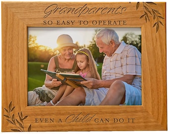 May include: A wooden picture frame with the words "Grandparents, so easy to operate, even a child can do it" engraved on the frame. The frame holds a photo of grandparents and a child looking at a book.