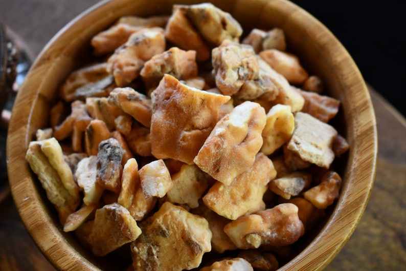 May include: A wooden bowl filled with light brown and white resin pieces.