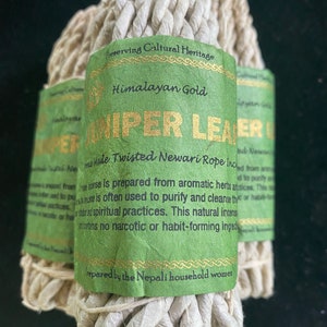 May include: Three bundles of Juniper Leaf incense, wrapped with green labels featuring gold text. The labels read "Himalayan Gold" and "Preserving Cultural Heritage." The incense is made from aromatic herbs and is used for purification.