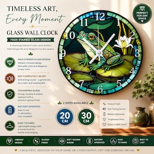 May include: A round wall clock featuring a faux stained glass design of a green frog sitting on a lily pad with a white water lily. The clock face has black numbers from 1 to 12, white hands, and a glossy finish. It is available in 20 cm and 30 cm.