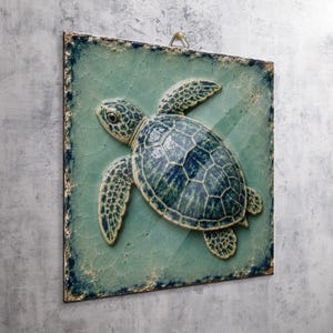 May include: A square ceramic wall plaque featuring a raised, three-dimensional sea turtle in shades of deep blue and teal. The background has a light green crackle glaze finish with dark, distressed edges and a metal hanging loop at the top.
