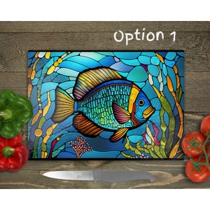 May include: A rectangular glass cutting board featuring a stained glass style illustration of a tropical fish in shades of blue, yellow, and orange, surrounded by aquatic plants and coral. The text Option 1 is printed in white at the top.