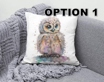 May include: A white cushion with a watercolour illustration of a baby owl with large eyes. The owl is brown and white with a light pink and blue watercolour background.