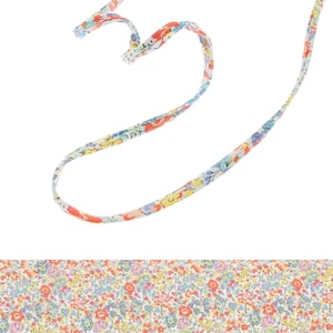 May include: A floral patterned ribbon in a variety of colors, including red, yellow, blue, and green, against a white background. The ribbon is curved and appears to be made of fabric. The bottom of the image shows a close-up of the same floral pattern.