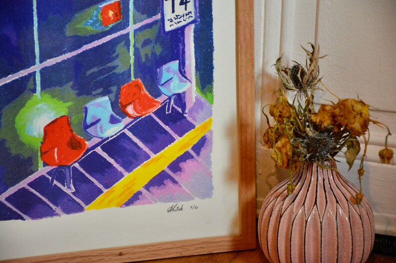 Puede incluir: Una impresi&oacute;n enmarcada de una pintura colorida que representa una fila de sillas rojas y azules en una sala de espera. La pintura est&aacute; firmada y numerada 4/20. La impresi&oacute;n est&aacute; colgada en una pared junto a un jarr&oacute;n con flores secas.