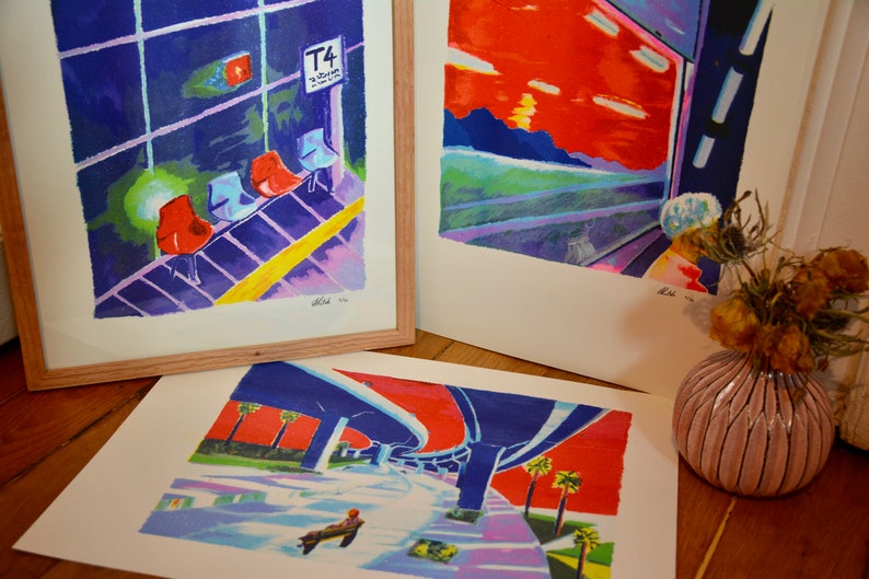 Puede incluir: Tres impresiones de arte enmarcadas con dise&ntilde;os abstractos coloridos. La impresi&oacute;n superior izquierda presenta un fondo azul y morado con sillas rojas y una l&iacute;nea amarilla. La impresi&oacute;n superior derecha presenta una puesta de sol roja y naranja con un cielo azul y morado. La impresi&oacute;n inferior presenta un paso subterr&aacute;neo azul y morado con un cielo rojo y palmeras.