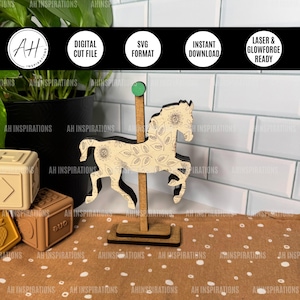 May include: A wooden carousel horse with a floral design, standing on a wooden base. The horse is light-coloured with a dark outline and floral pattern. The carousel horse is approximately 15 cm tall.