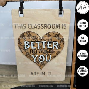 May include: A wooden sign with the text "This classroom is better because you are in it!"  The text is surrounded by a heart shape with a decorative pattern.