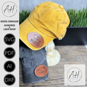 May include: Two baseball caps with brown leather patches. The yellow cap has a patch that says "Stay Rooted". The gray cap has a patch that says "Exist Happy".