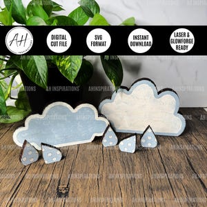 May include: A set of wooden craft cutouts for a rain cloud theme. The set includes two clouds, one with a white background and one with a light blue background, and four raindrops with white polka dots.