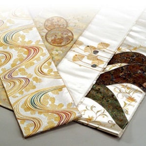 Pu&ograve; includere: Un set di tre pannelli in tessuto di seta bianca con disegni dorati e marroni. I pannelli presentano una variet&agrave; di motivi, tra cui linee a spirale, foglie e forme geometriche.